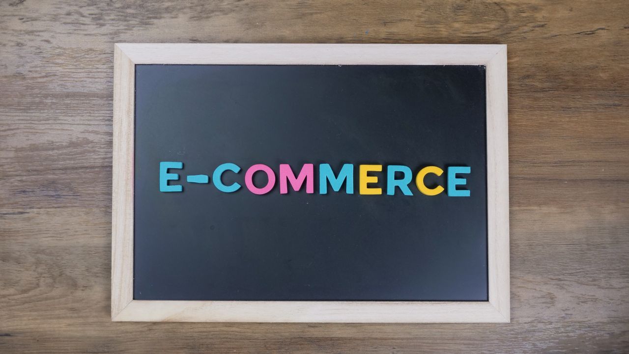 services-04 Colorful letters spelling e-commerce on a wooden framed blackboard.